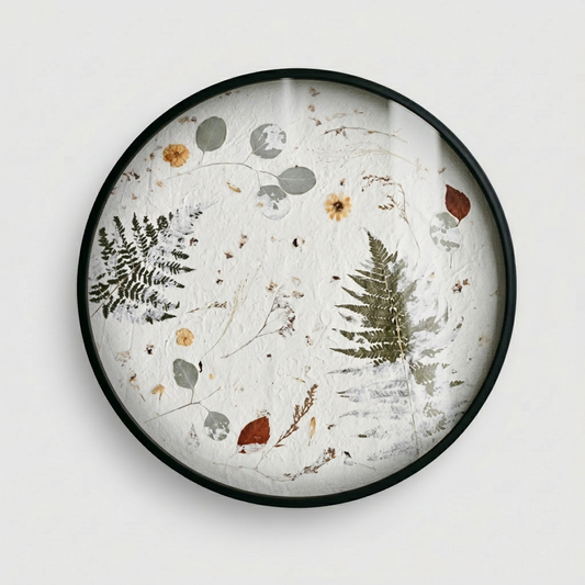 Joanna Jernajczyk for Nudiflorum R55/05 — circular botanical wall art with pressed ferns, eucalyptus, dried flowers and meadow botanicals on white textured ground, black metal frame, 55 cm