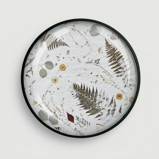 Joanna Jernajczyk for Nudiflorum R55/07 — circular botanical wall art with pressed ferns, eucalyptus, dried flowers and meadow botanicals on white textured ground, black metal frame, 55 cm