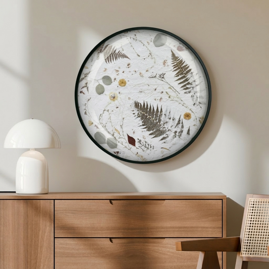The Nudiflorum R55/07 wall art hangs on a wall in a warm taupe shade above a wooden chest of drawers, on which a lamp stands. Next to it is a chair with Viennese wickerwork. Natural daylight