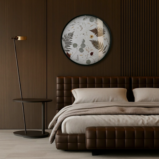 The Nudiflorum R55/09 wall decoration with a floral motif in a modern, dark bedroom, above a bed upholstered in dark brown leather, with a side table and a lamp beside it. The wall behind the bed is finished with wooden panelling