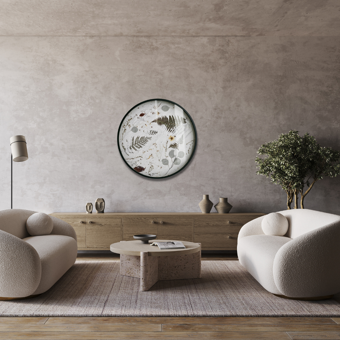 Nudiflorum R55/10 circular botanical wall art displayed on a raw concrete wall above a minimal living room with cream boucle armchairs and stone coffee table